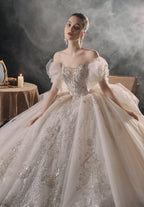 Vestido de Noiva Etéreo com Ombros Descobertos, Laço de Tule e Saia Rodada, com Cauda de Catedral e Aplicações de Renda com Cristais