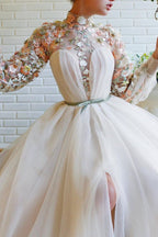 Vestidos de baile brancos com mangas compridas, corte evasê, gola alta, tule, flores e cauda de sereia com racha