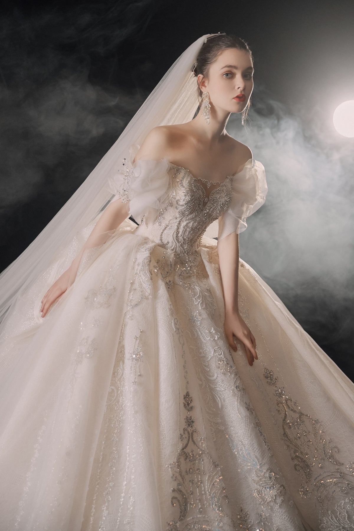 Vestido de Noiva Etéreo com Ombros Descobertos, Laço de Tule e Saia Rodada, com Cauda de Catedral e Aplicações de Renda com Cristais