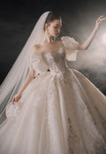 Vestido de Noiva Etéreo com Ombros Descobertos, Laço de Tule e Saia Rodada, com Cauda de Catedral e Aplicações de Renda com Cristais