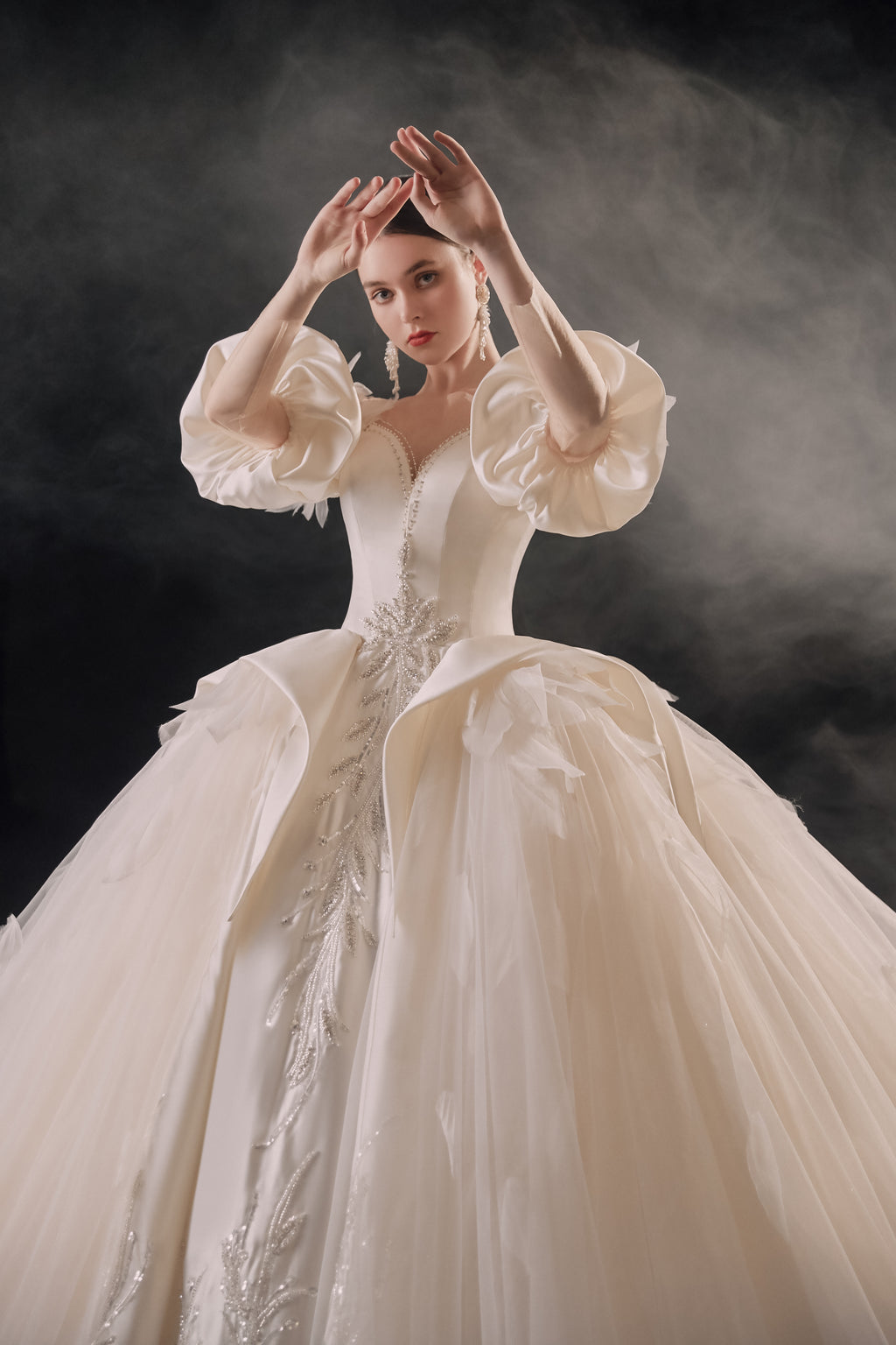 Abito da sposa etereo in raso con piume, scollatura a spalle scoperte, gonna ampia, strascico a cattedrale e dettagli in cristallo