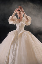Abito da sposa etereo in raso con piume, scollatura a spalle scoperte, gonna ampia, strascico a cattedrale e dettagli in cristallo