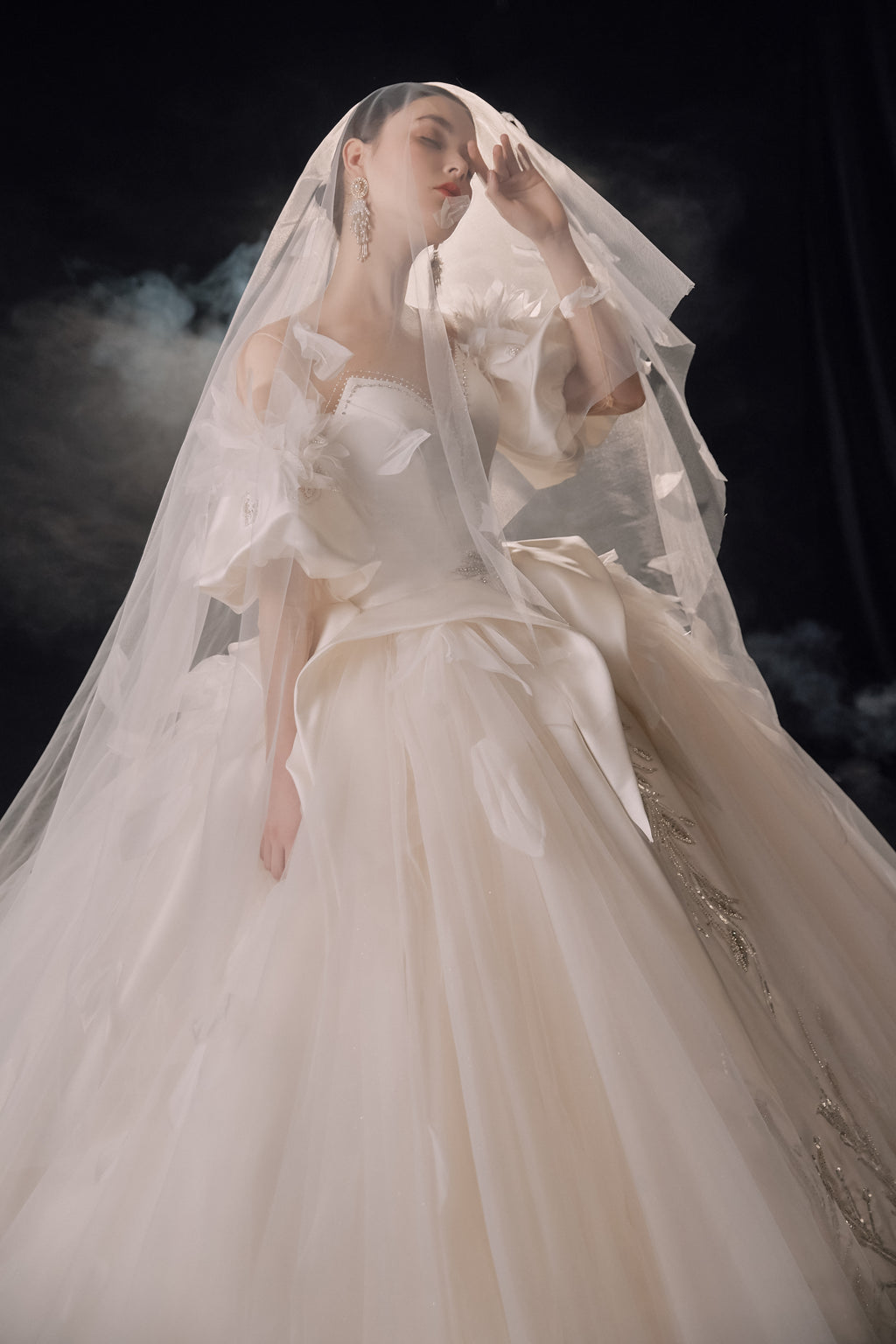 Abito da sposa etereo in raso con piume, scollatura a spalle scoperte, gonna ampia, strascico a cattedrale e dettagli in cristallo