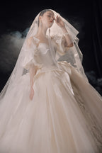 Abito da sposa etereo in raso con piume, scollatura a spalle scoperte, gonna ampia, strascico a cattedrale e dettagli in cristallo