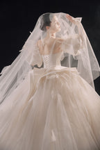 Abito da sposa etereo in raso con piume, scollatura a spalle scoperte, gonna ampia, strascico a cattedrale e dettagli in cristallo