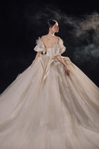 Abito da sposa etereo in raso con piume, scollatura a spalle scoperte, gonna ampia, strascico a cattedrale e dettagli in cristallo