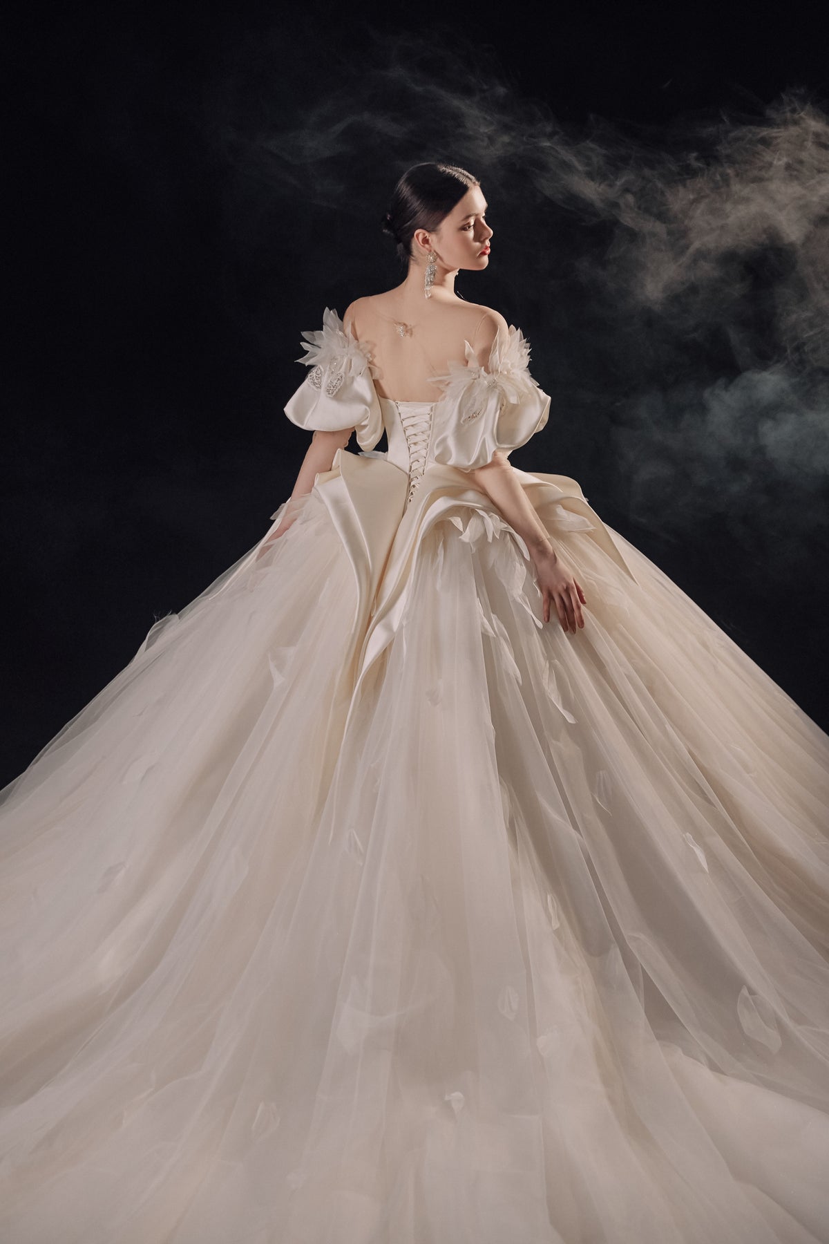 Abito da sposa etereo in raso con piume, scollatura a spalle scoperte, gonna ampia, strascico a cattedrale e dettagli in cristallo