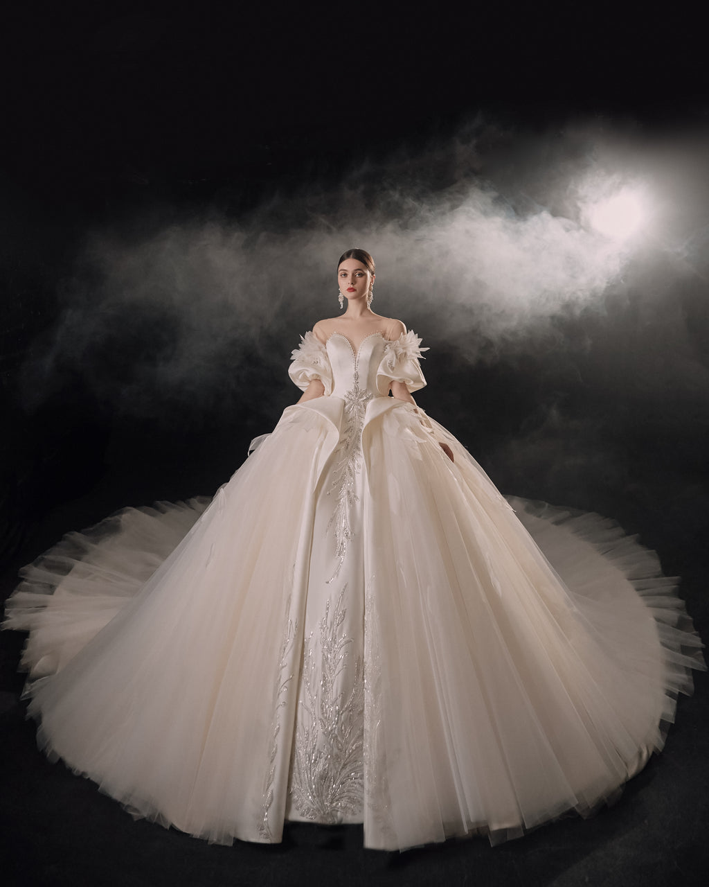 Abito da sposa etereo in raso con piume, scollatura a spalle scoperte, gonna ampia, strascico a cattedrale e dettagli in cristallo