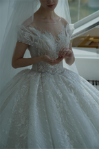 Abito da sposa etereo con pizzo a spalle scoperte, dettagli in cristallo e strascico a cattedrale