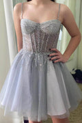Abito da sera in tulle grigio argento con paillettes e spalline sottili, con balza