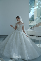 Abito da sposa etereo con pizzo a spalle scoperte, dettagli in cristallo e strascico a cattedrale