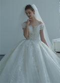 Abito da sposa etereo con pizzo a spalle scoperte, dettagli in cristallo e strascico a cattedrale