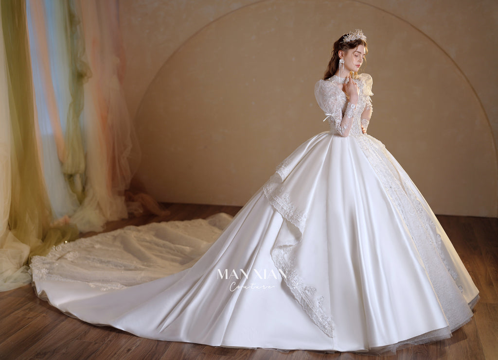 Abito da sposa in raso cristallino con collo alto, maniche a sbuffo e strascico a cattedrale