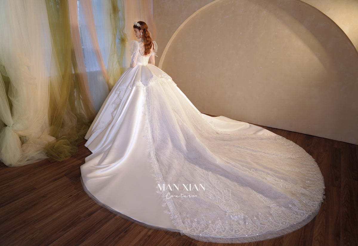 Abito da sposa in raso cristallino con collo alto, maniche a sbuffo e strascico a cattedrale