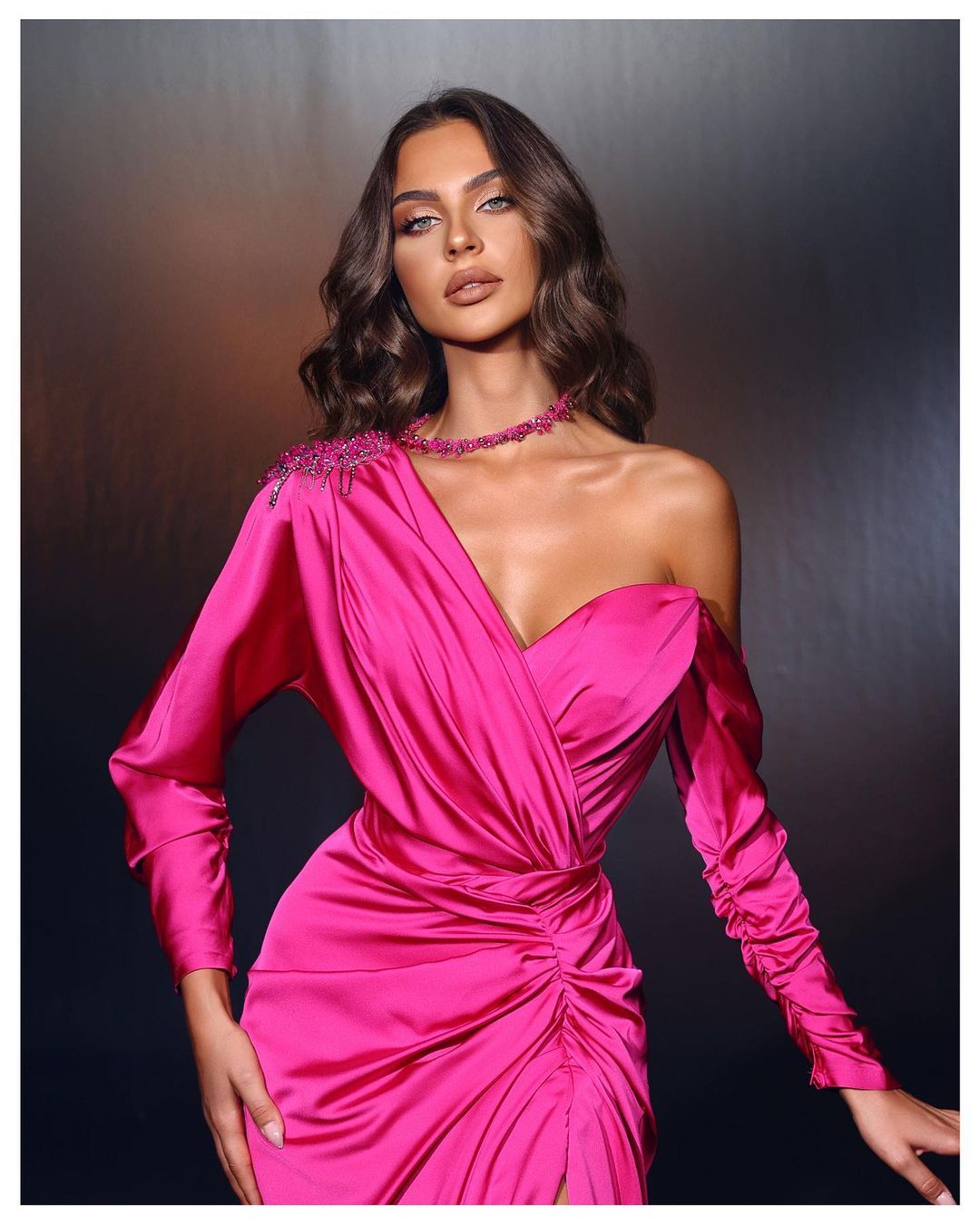 Abito da sera lungo fucsia con una spalla, perline, maniche lunghe e spacco