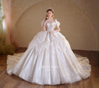 Abito da sposa etereo con scollo a spalle scoperte, gonna a sfera, strascico a cattedrale e applicazioni di pizzo