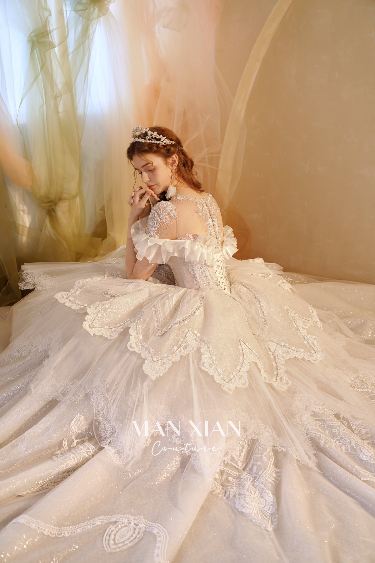 Abito da sposa etereo con scollo a spalle scoperte, gonna a sfera, strascico a cattedrale e applicazioni di pizzo