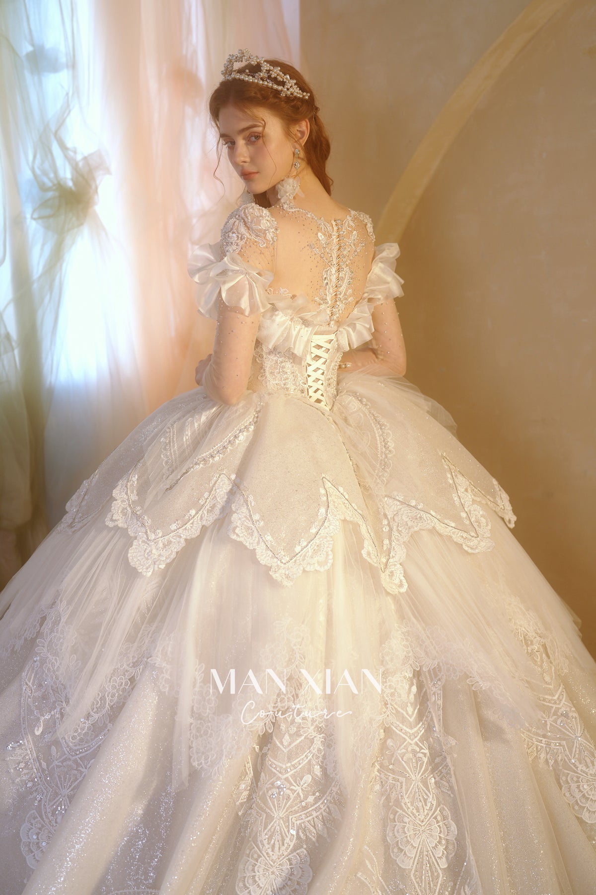 Abito da sposa etereo con scollo a spalle scoperte, gonna a sfera, strascico a cattedrale e applicazioni di pizzo