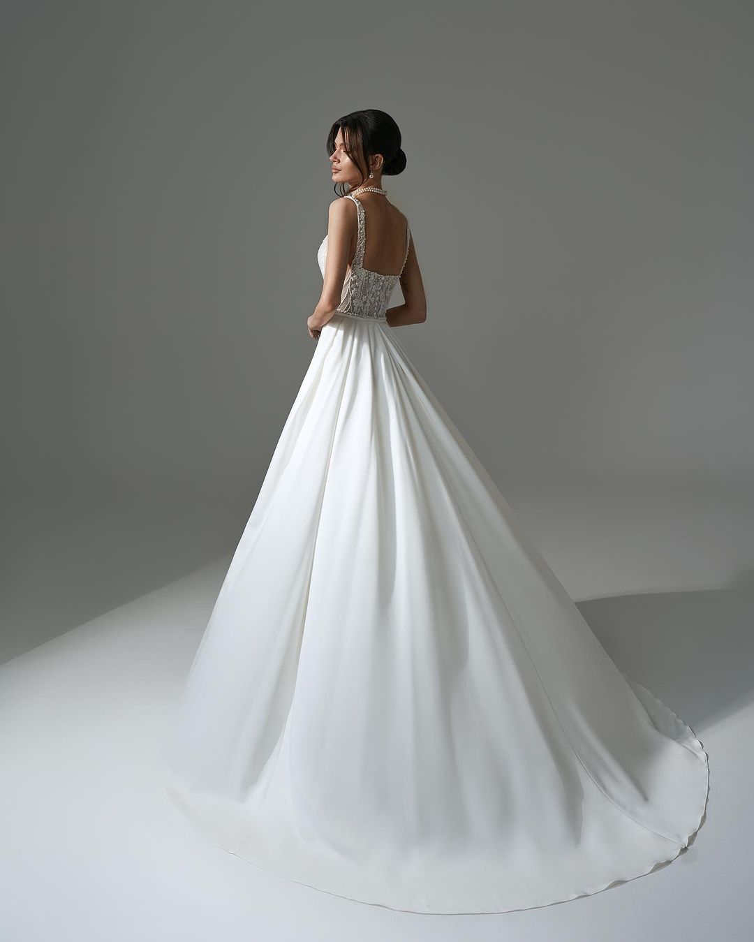 Robe de mariée élégante longue blanche en dentelle perlée sans manches, coupe évasée, avec fente