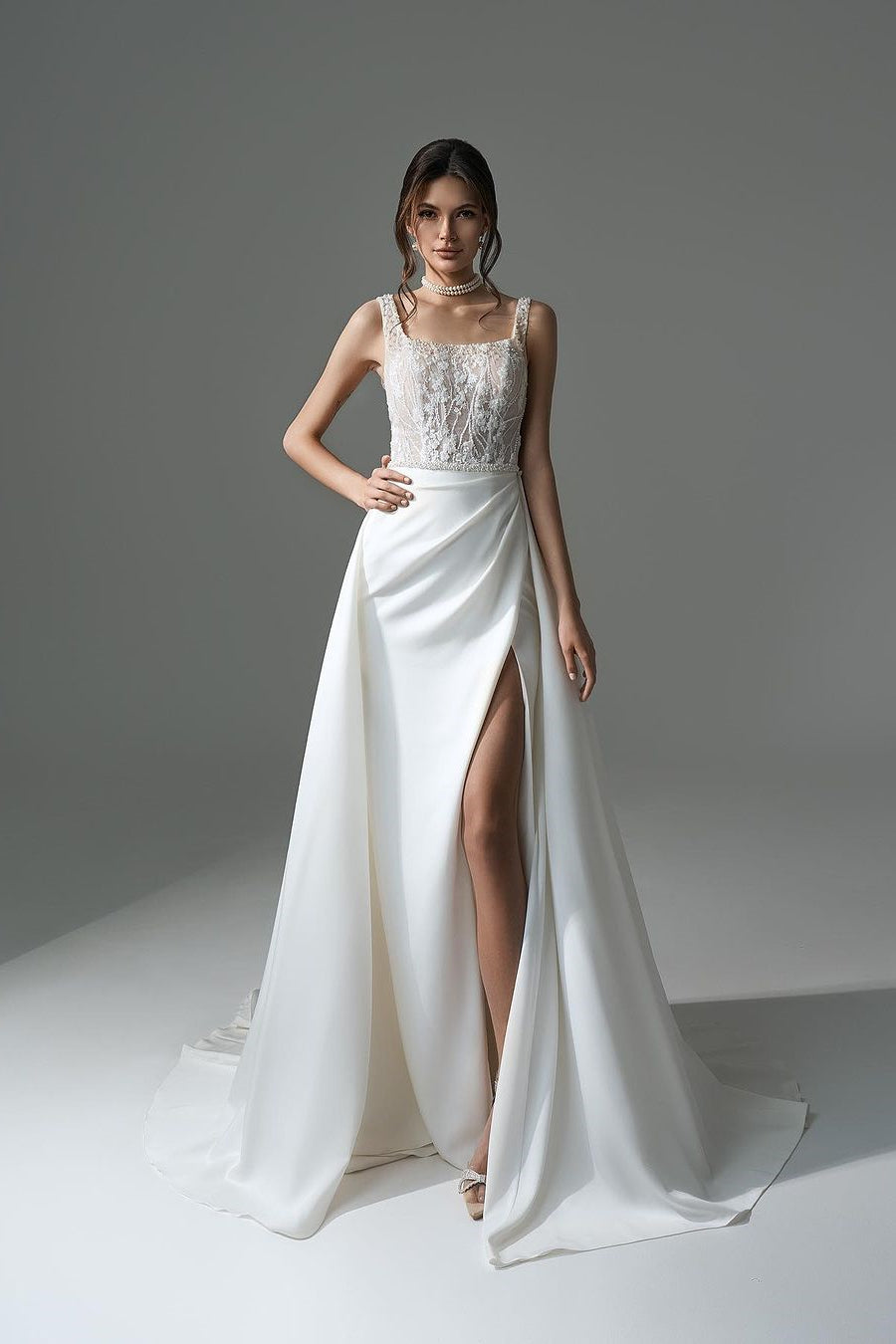 Robe de mariée élégante longue blanche en dentelle perlée sans manches, coupe évasée, avec fente