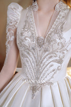 Abito da sposa di raso cristallino con scollo a V, gonna a palloncino, fiocco posteriore oversize e strascico a cattedrale
