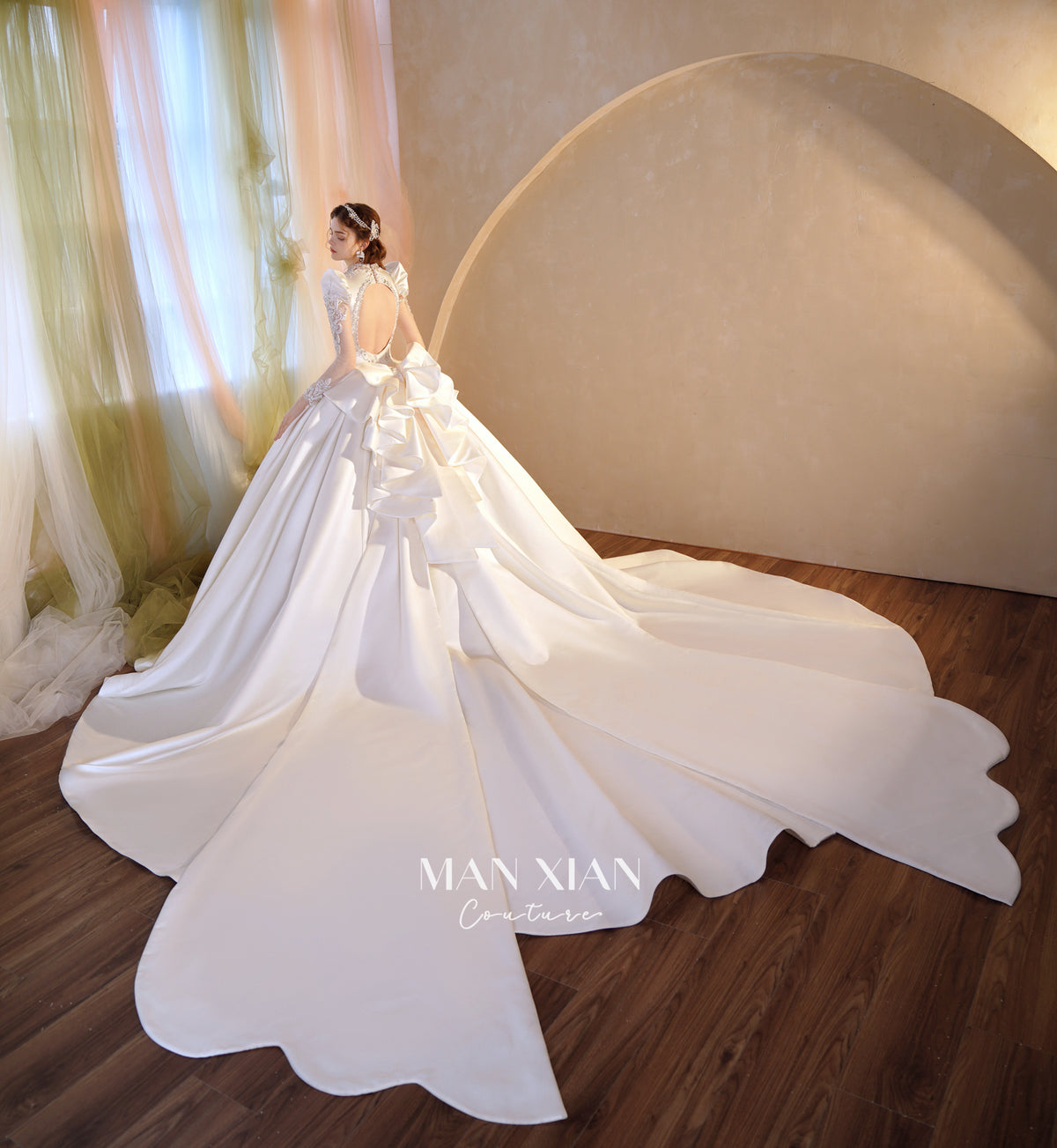 Abito da sposa di raso cristallino con scollo a V, gonna a palloncino, fiocco posteriore oversize e strascico a cattedrale