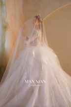 Abito da sposa etereo in tulle cristallino con scollo a V, maniche lunghe e strascico a cattedrale