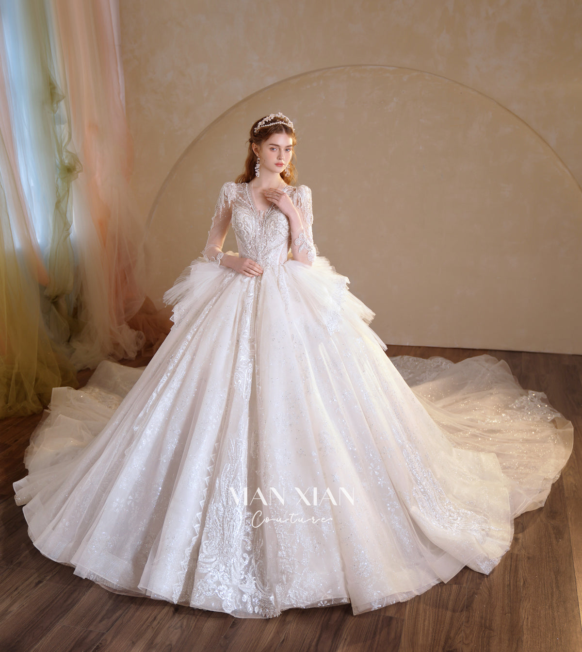 Abito da sposa etereo in tulle cristallino con scollo a V, maniche lunghe e strascico a cattedrale