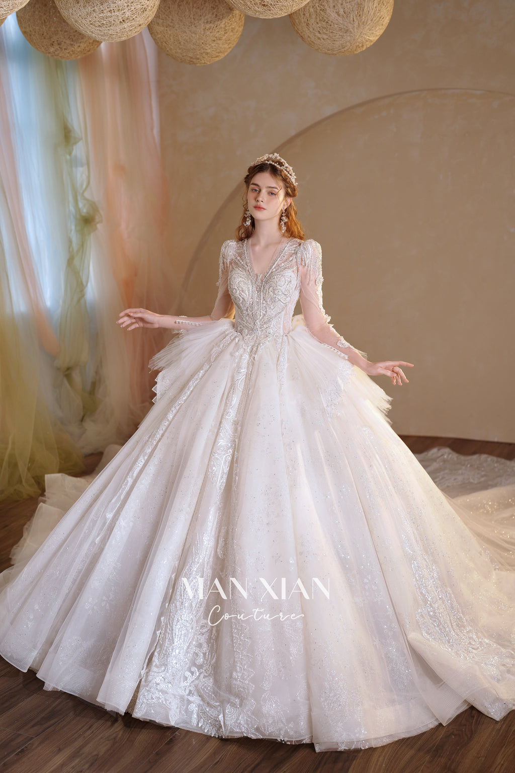 Abito da sposa etereo in tulle cristallino con scollo a V, maniche lunghe e strascico a cattedrale