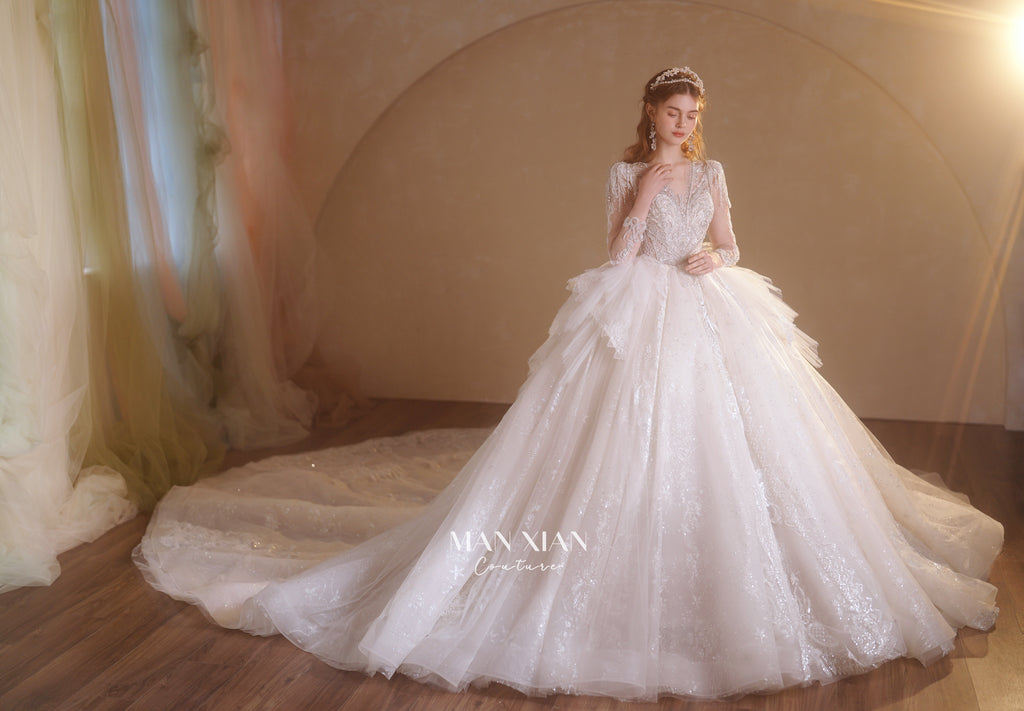 Abito da sposa etereo in tulle cristallino con scollo a V, maniche lunghe e strascico a cattedrale