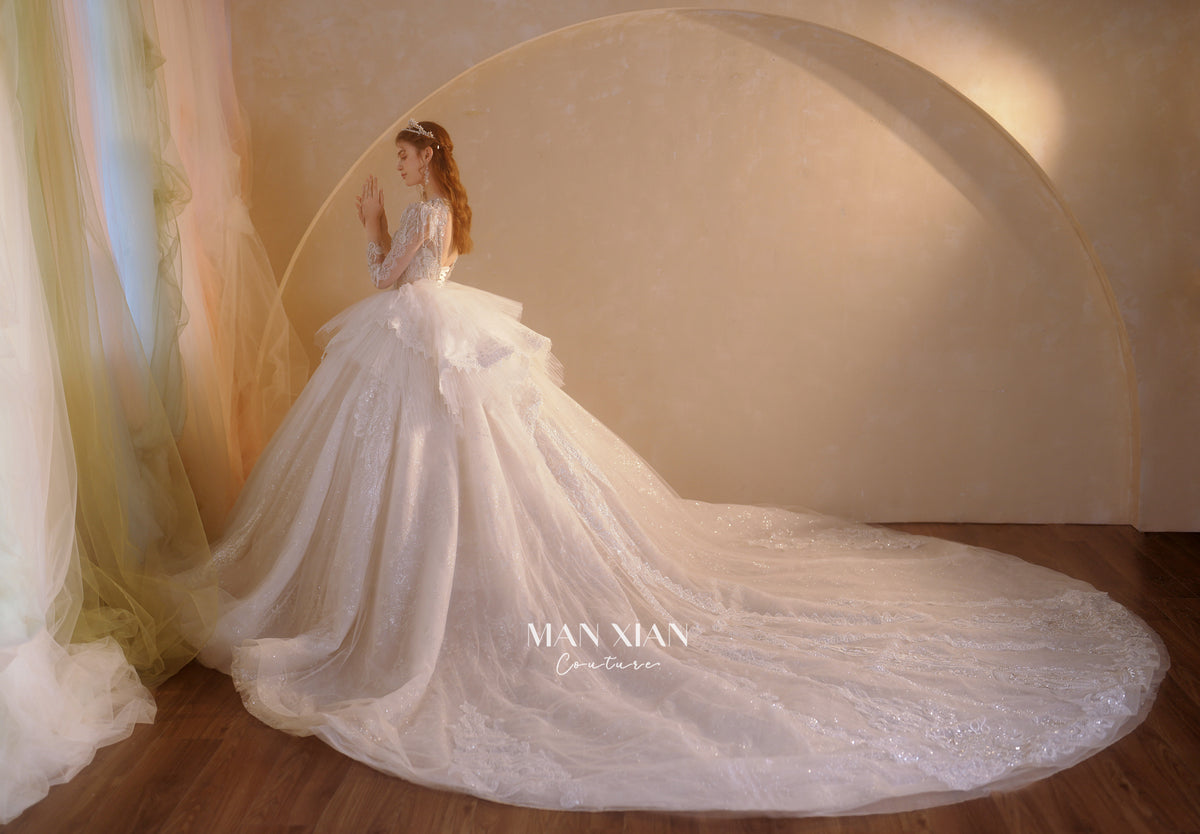 Abito da sposa etereo in tulle cristallino con scollo a V, maniche lunghe e strascico a cattedrale