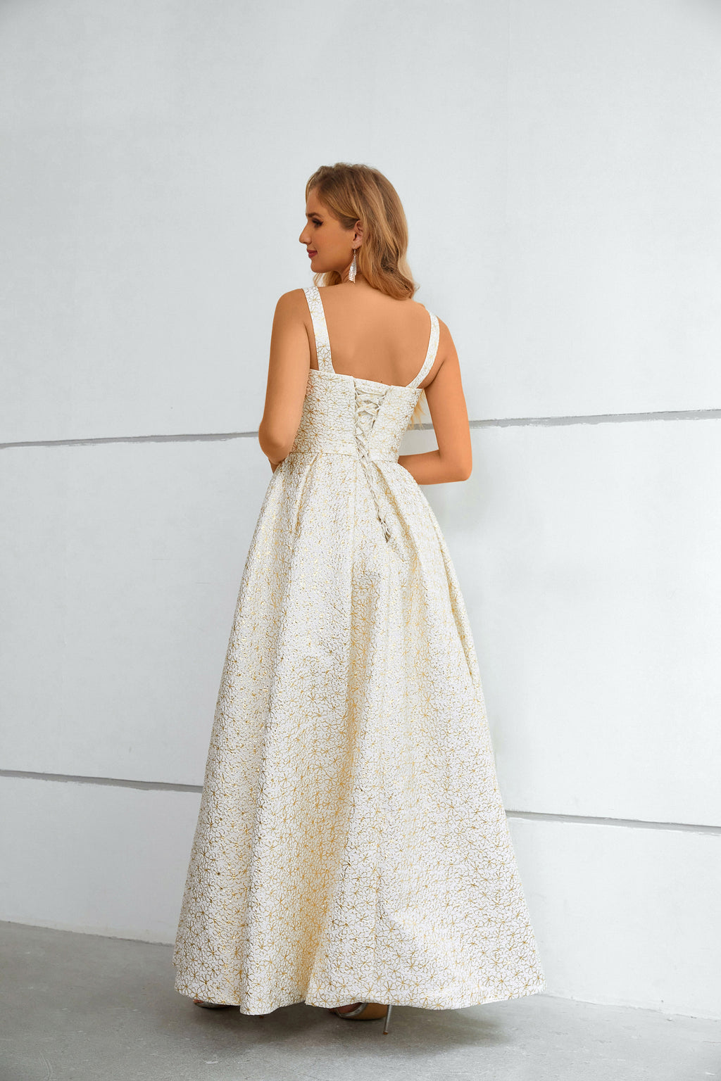 Vestido comprido branco e dourado com padrão floral, decote quadrado texturado e racha alta