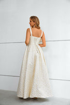 Vestido comprido branco e dourado com padrão floral, decote quadrado texturado e racha alta