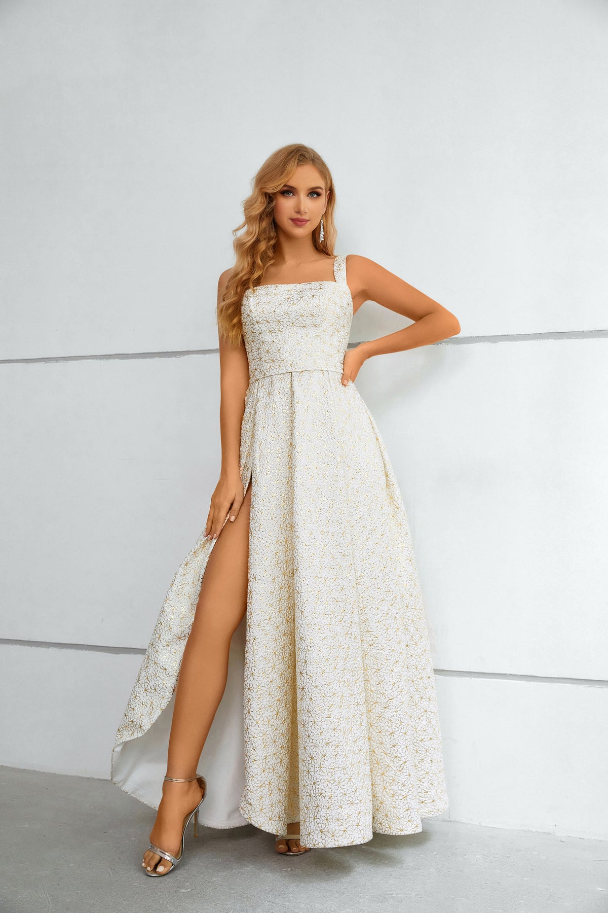 Vestido comprido branco e dourado com padrão floral, decote quadrado texturado e racha alta