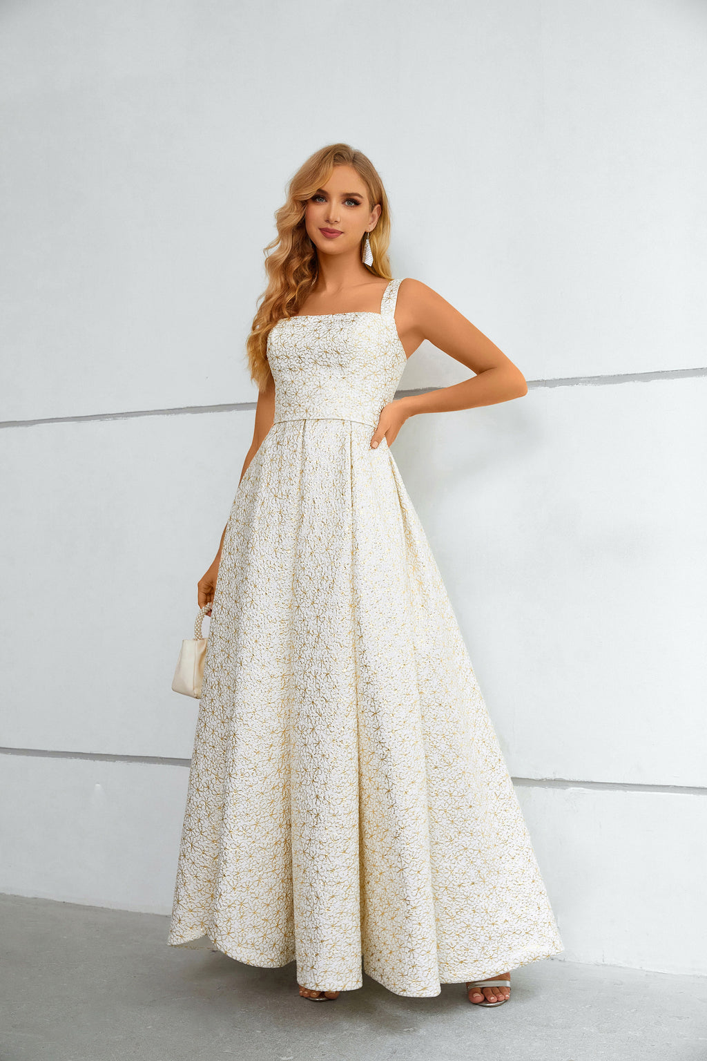 Vestido comprido branco e dourado com padrão floral, decote quadrado texturado e racha alta