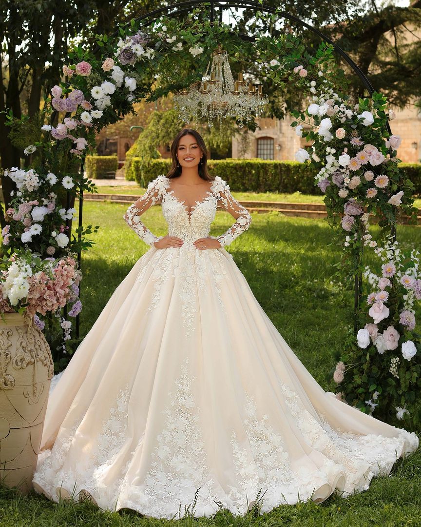 Vestido de novia largo color marfil estilo princesa, con mangas largas, apliques y cola
