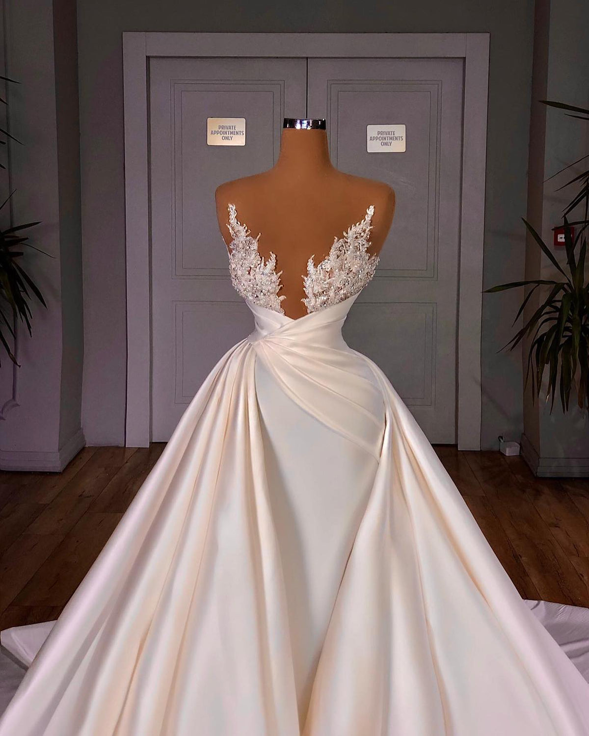 Elegante vestido de novia largo con escote en V, sin mangas y corte catedral.