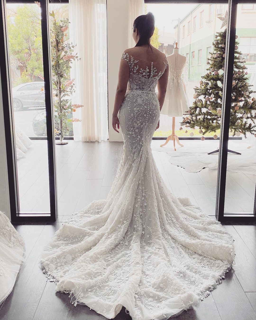 Elegante abito da sposa lungo a sirena con spalle scoperte, pizzi applicati e schiena scoperta