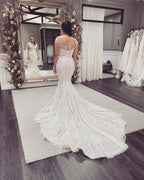 Elegante abito da sposa lungo a sirena con spalle scoperte, pizzi applicati e schiena scoperta