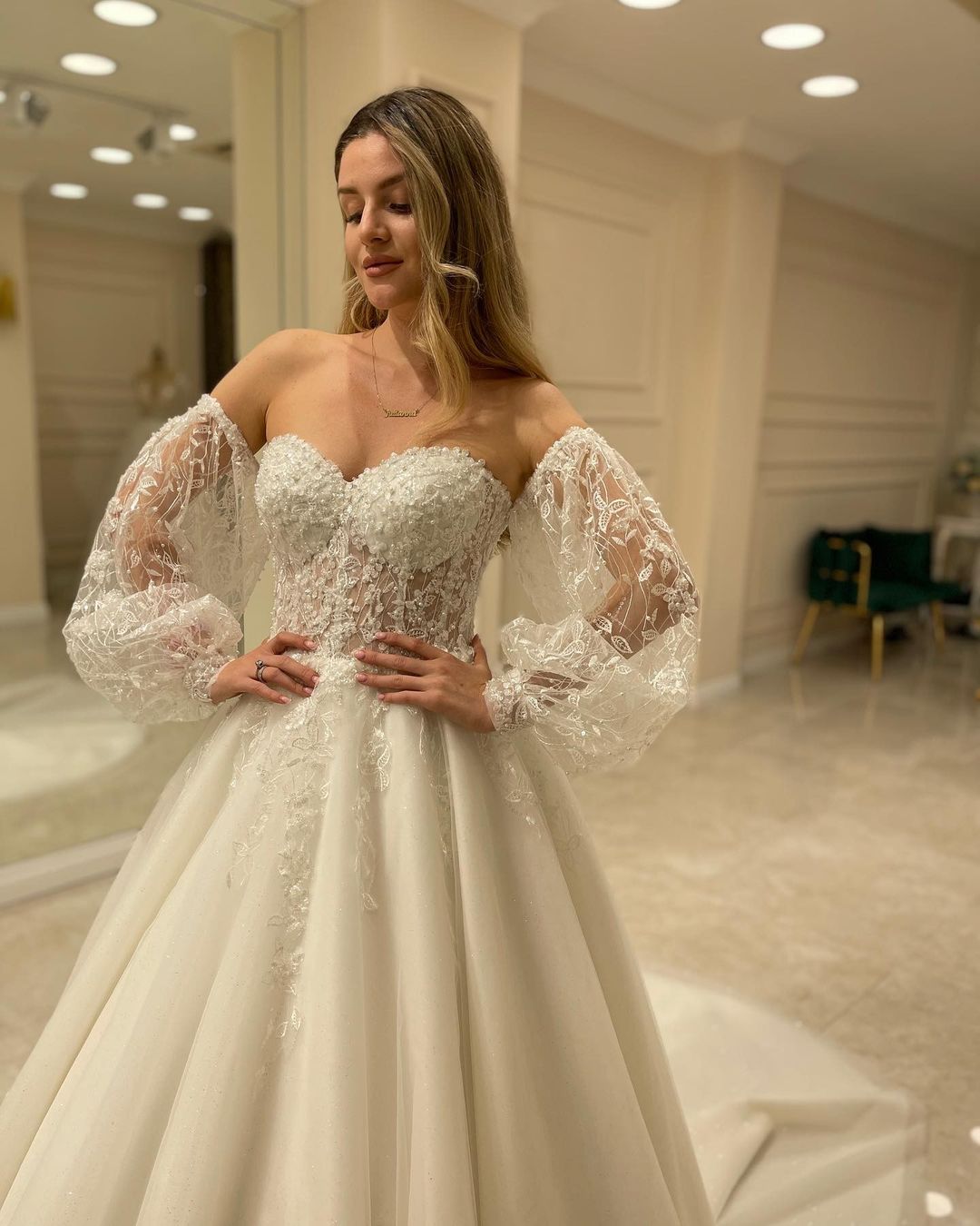 Abito da sposa elegante con maniche lunghe, linea a trapezio, scollo a cuore, schiena scoperta e applicazioni in pizzo