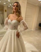 Abito da sposa elegante con maniche lunghe, linea a trapezio, scollo a cuore, schiena scoperta e applicazioni in pizzo