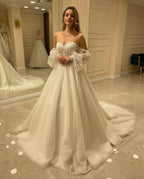 Abito da sposa elegante con maniche lunghe, linea a trapezio, scollo a cuore, schiena scoperta e applicazioni in pizzo