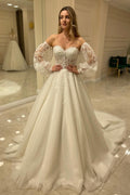 Abito da sposa elegante con maniche lunghe, linea a trapezio, scollo a cuore, schiena scoperta e applicazioni in pizzo