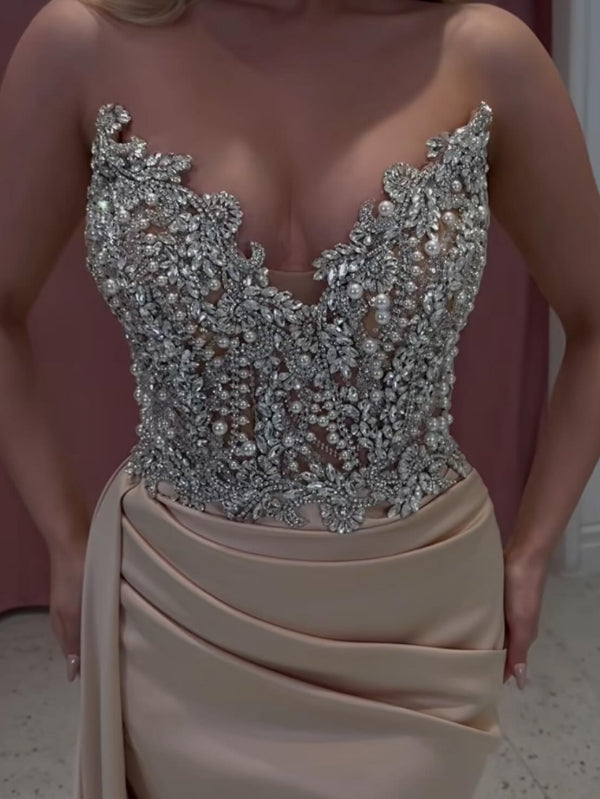 Exquisito vestido de fiesta largo color champán con corte sirena, sin tirantes y con joyas