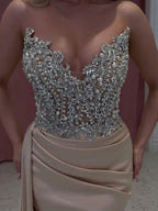 Exquisito vestido de fiesta largo color champán con corte sirena, sin tirantes y con joyas