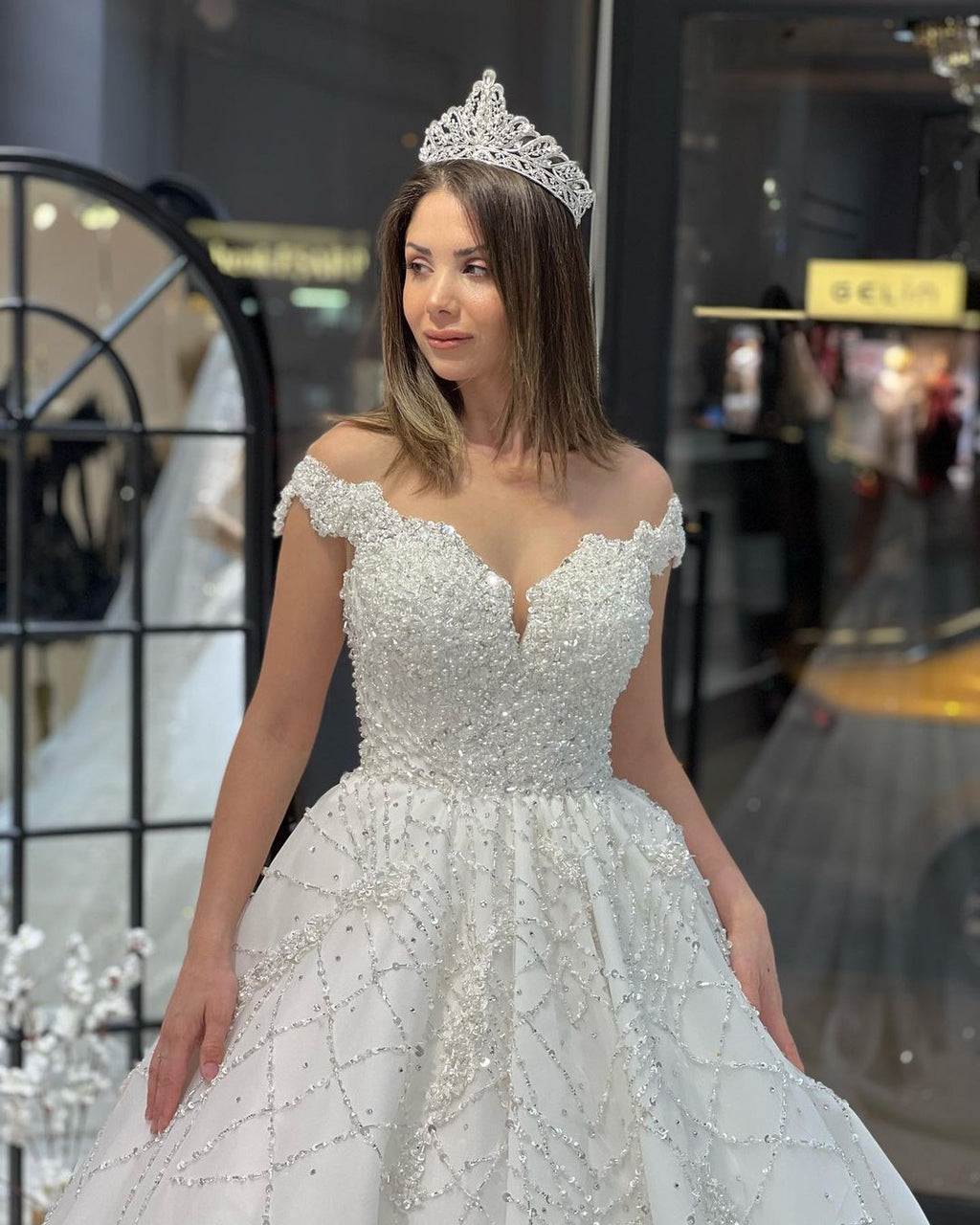 Robe de mariée fabuleuse longue jusqu'au sol, décolleté cœur, épaules dénudées, coupe en A, ornée de paillettes avec volants