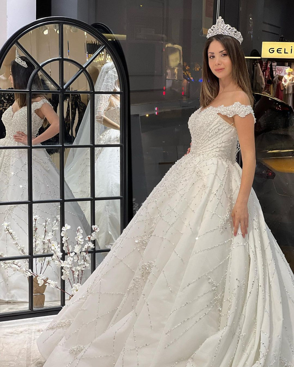 Robe de mariée fabuleuse longue jusqu'au sol, décolleté cœur, épaules dénudées, coupe en A, ornée de paillettes avec volants