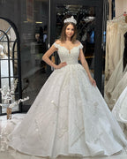 Robe de mariée fabuleuse longue jusqu'au sol, décolleté cœur, épaules dénudées, coupe en A, ornée de paillettes avec volants