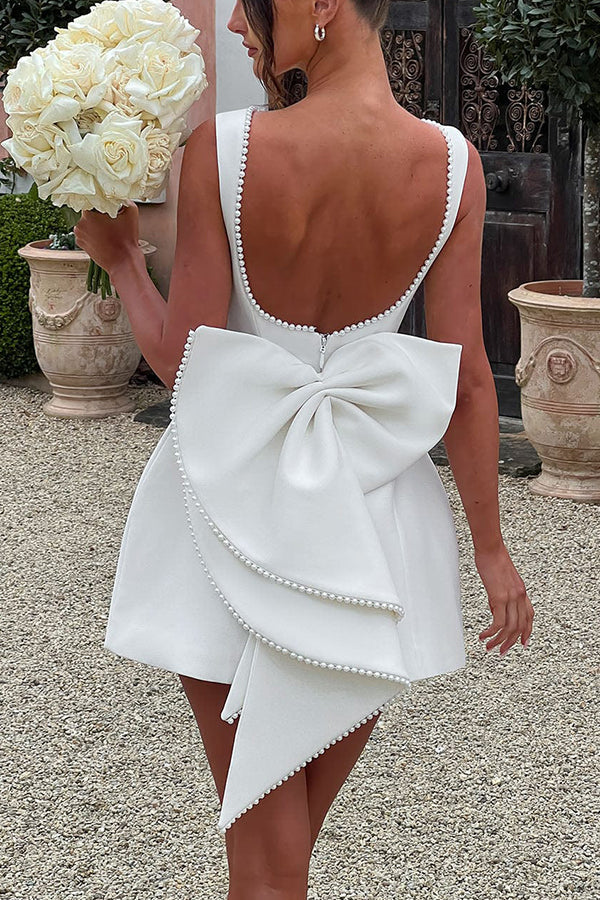 Abito corto aderente con grande fiocco decorato a perle elegante