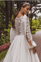 Magnifique robe de mariée blanche en satin à manches longues et coupe trapèze avec applications